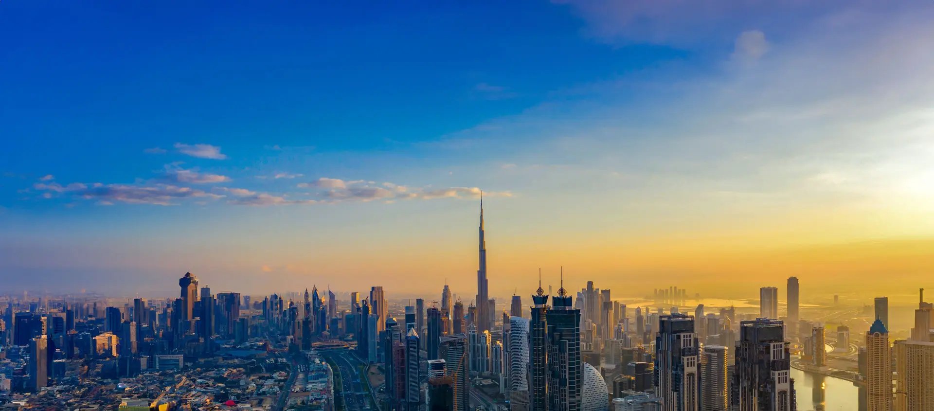 Dubai skyline at sunrise with the Burj Khalifa rising above the downtown towers
